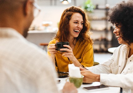 Friends smiling while enjoying coffee
