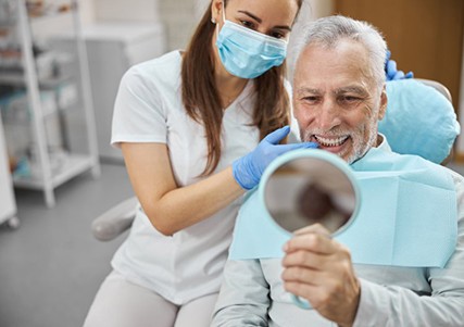 a patient checking his smile with a mirror