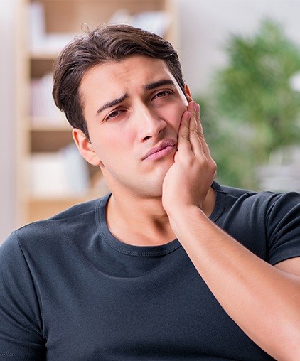 Man in pain holding jaw