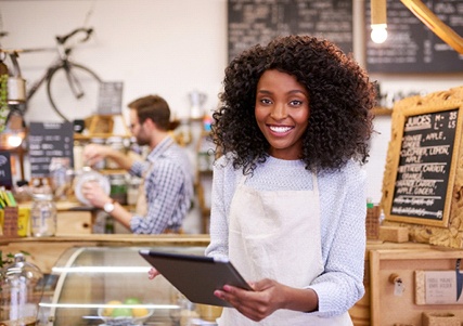 person at work who is smiling and holding a tablet