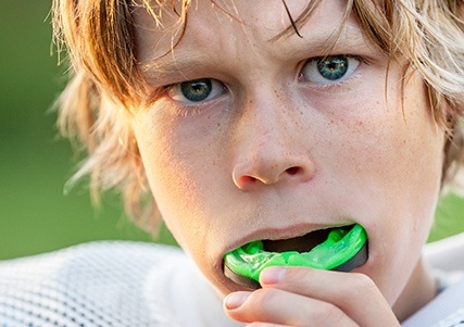 Teen boy placing athletic mouthguard