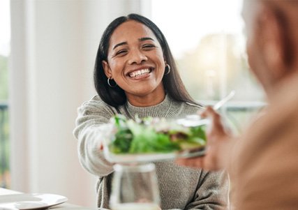 Woman showing off healthy smile while eating lunch  