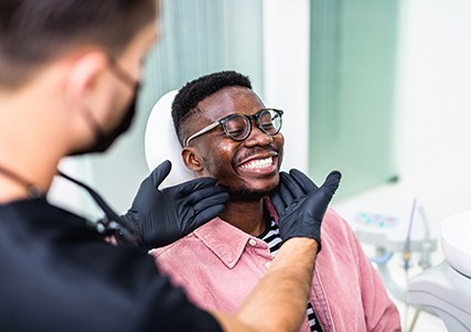 Dentist looking at patient's smile in treatment room
