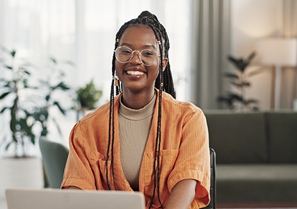 Woman with glasses smiling while working at home