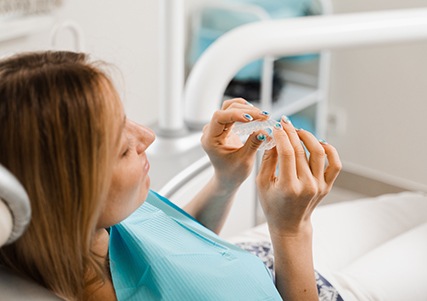 Patient holding clear aligner in treatment room