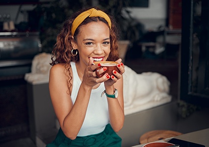 Woman smiling while enjoying cup of coffee