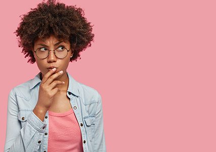 Woman on pink background wondering about ClearCorrect in Saginaw