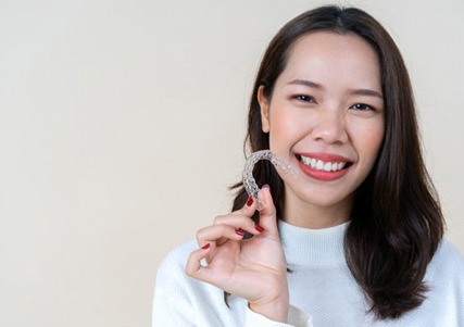 girl holding clear aligner