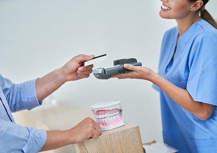 Patient using credit card to pay for dental treatment