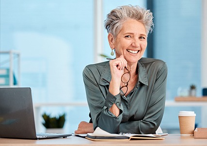 A smiling businessperson sitting in a corporate office