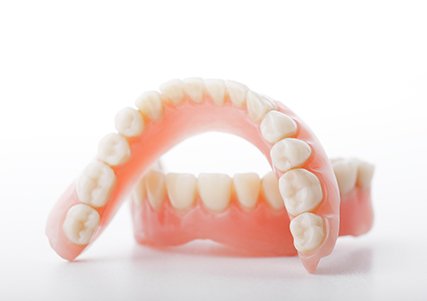 Close up of upper and lower dentures with white background