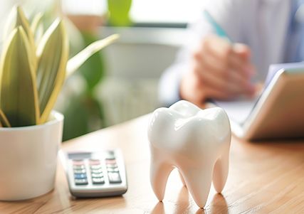 Prop tooth, calculator, and plant on table