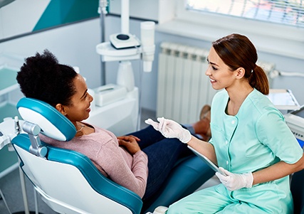 Dental assistant and patient smiling at each other