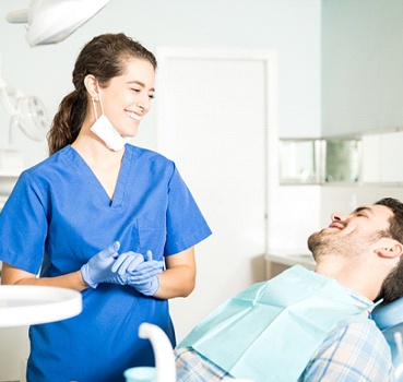 Cosmetic dentist and patient smiling during dental appointment