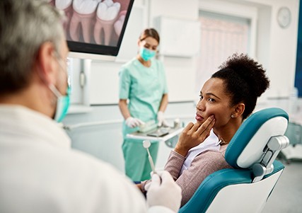 Patient with toothache looking at dentist in treatment chair