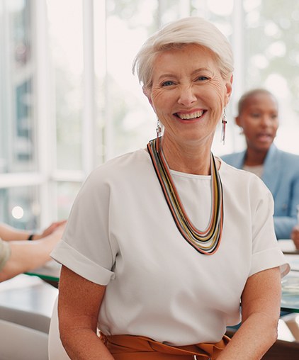 Older woman showing off smile after seeing Humana dentist in Saginaw