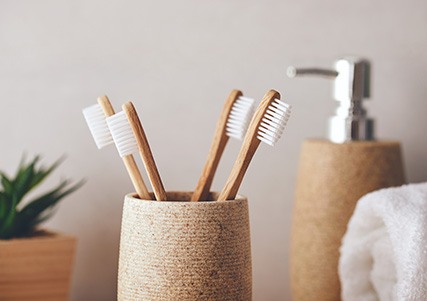 Multiple toothbrushes in cup on bathroom counter