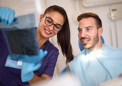 Team member showing patient dental x-rays