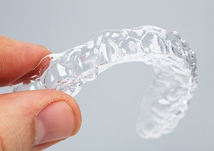 Hand holding a clear aligner