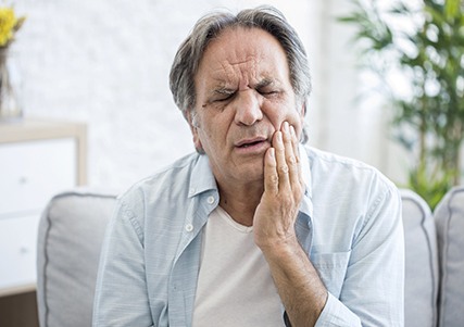 Man in pain needing full mouth reconstruction.