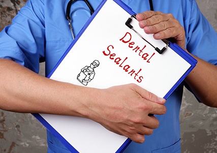 Dentist holding a sealants clipboard