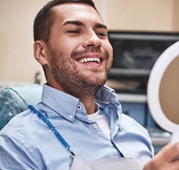 a patient checking his smile after teeth whitening