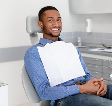 a patient smiling while waiting in the dental exam chair