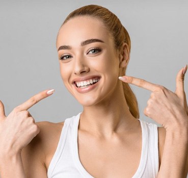 a woman pointing at her bright smile