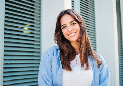 Woman with white teeth smiling while standing outside