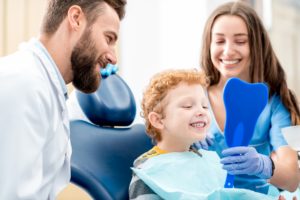 young boy smiling in chair at dentist in Saginaw