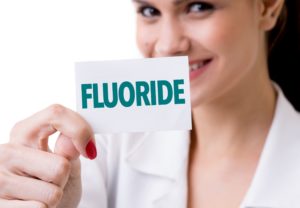 Dentist in Saginaw holding a fluoride card.