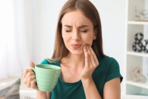 Woman experiencing a toothache with hand on his face