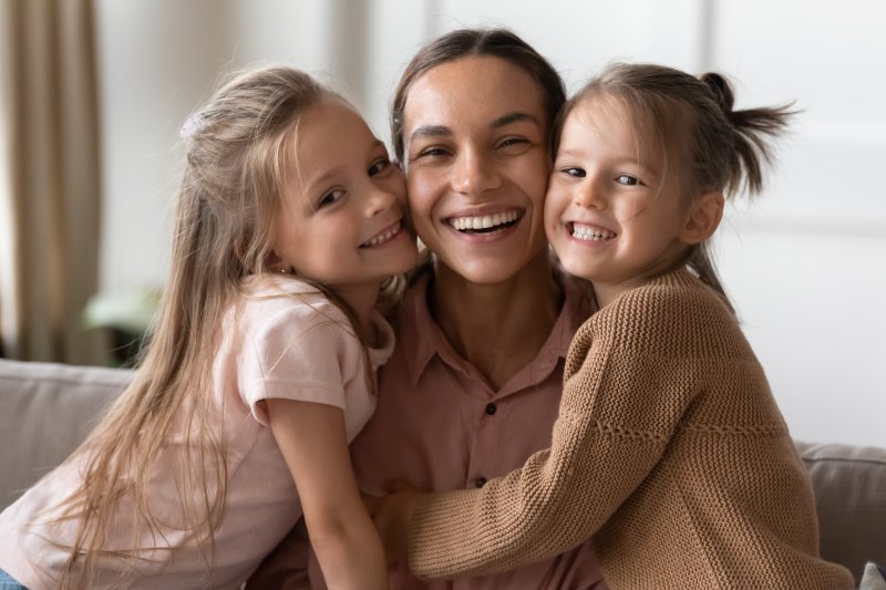 Mom smiling with two daughters