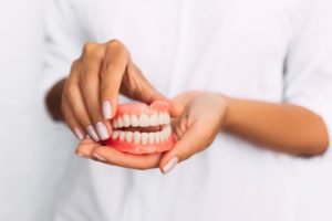 Woman holding complete denture